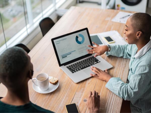 two women looking at a laptop screen 
