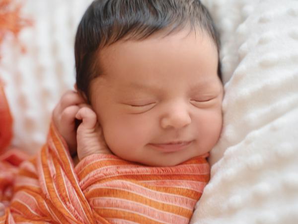 Baby wrapped in an orange blanket