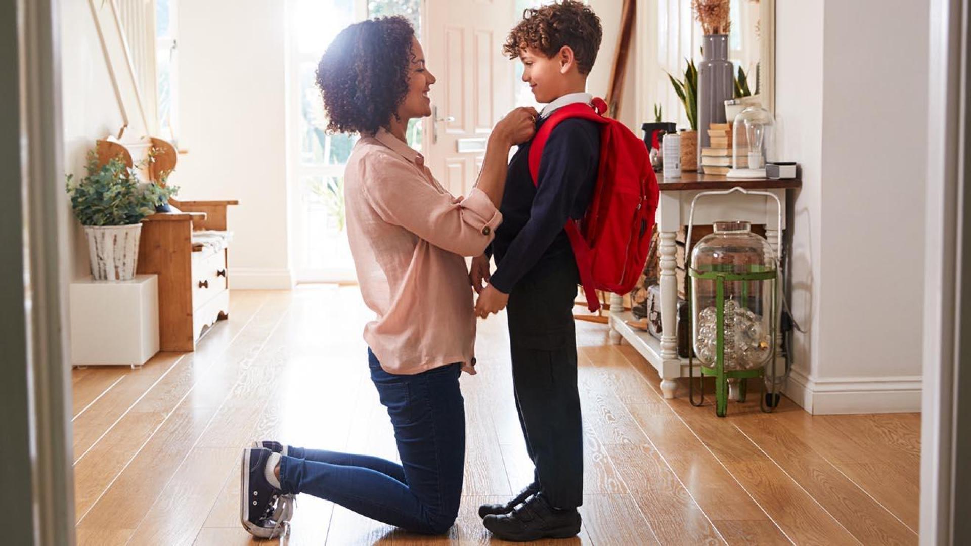 Starting school Image of a mum helping her little boy with his school uniform